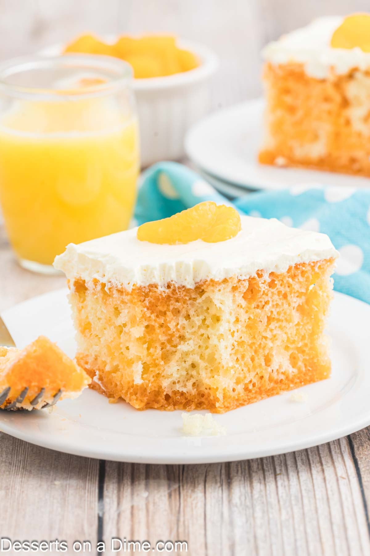 Orange Dreamsicle cake cut into slices on a plate.
