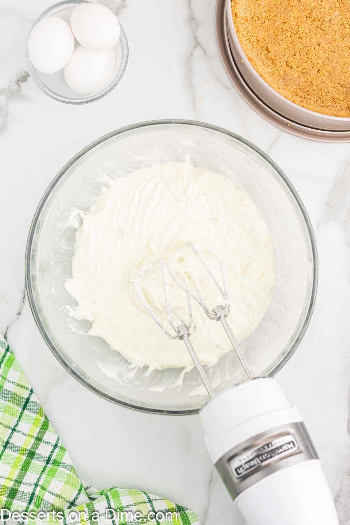 Cream cheese mixture being beat in a bowl. 