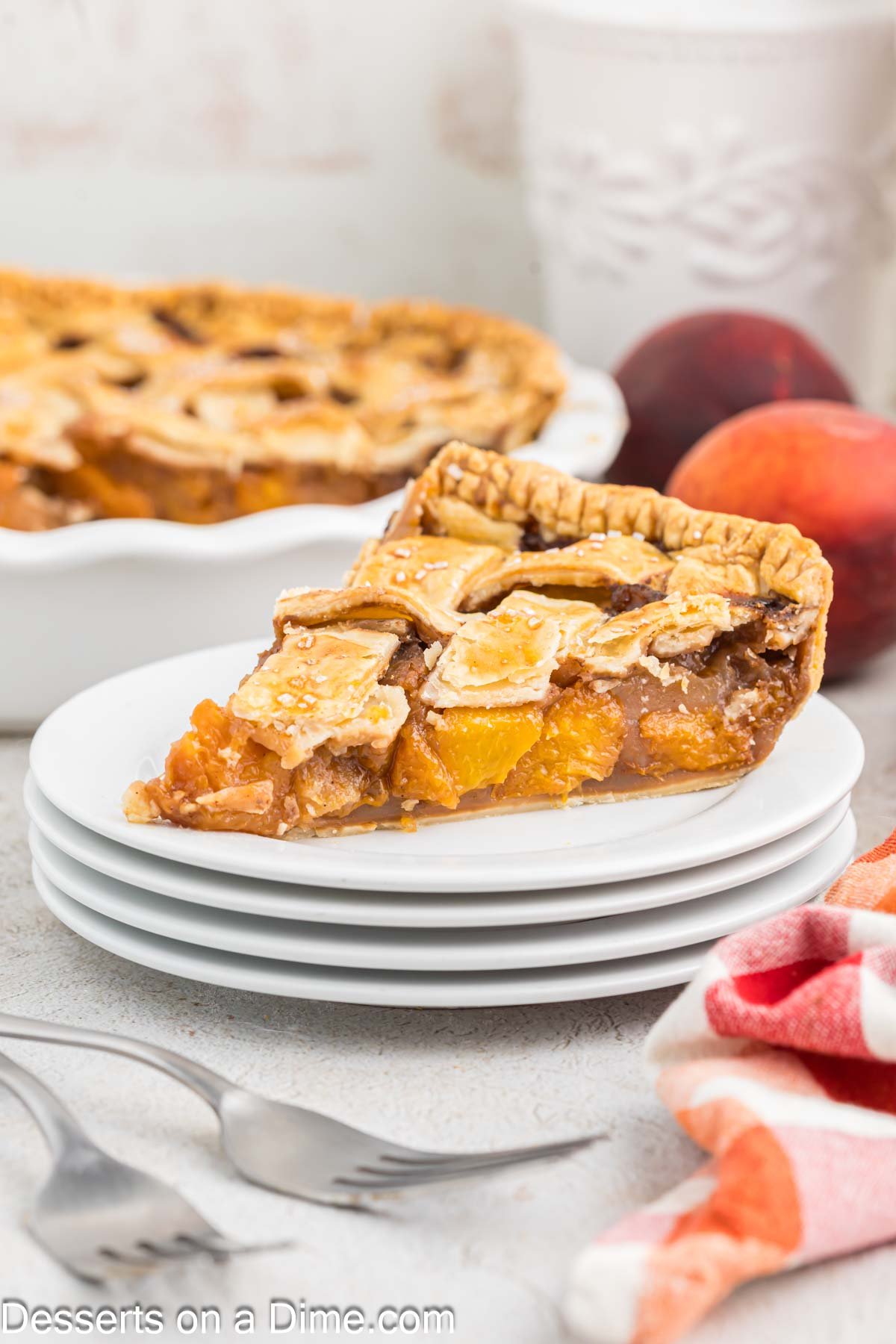 Slice of peach pie on white plate.