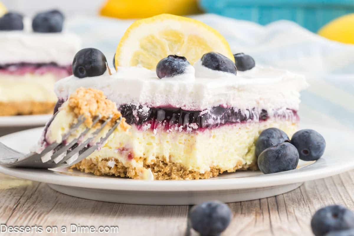Lemon Blueberry Delight sliced and served on white plate with a fork.