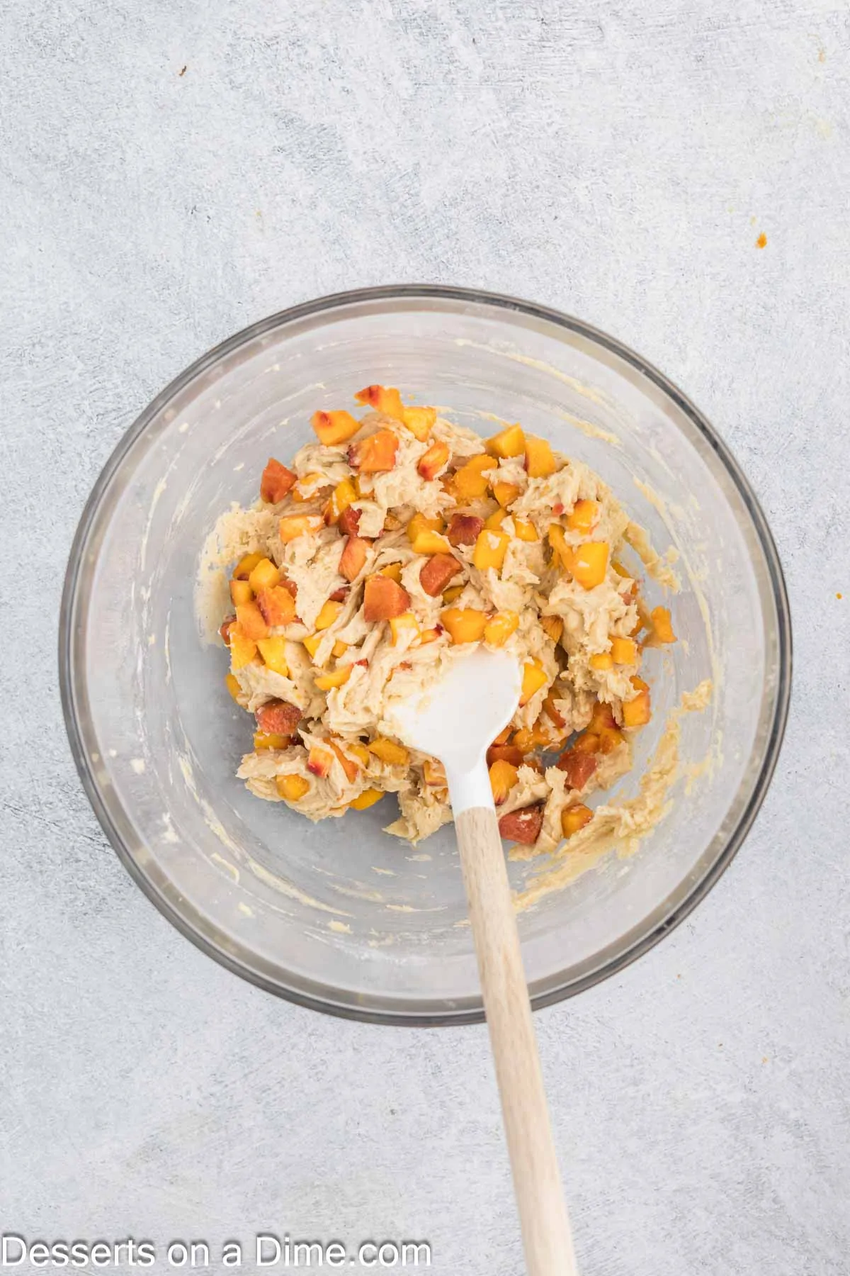 Wet and dry ingredients combined together with peaches folded in.