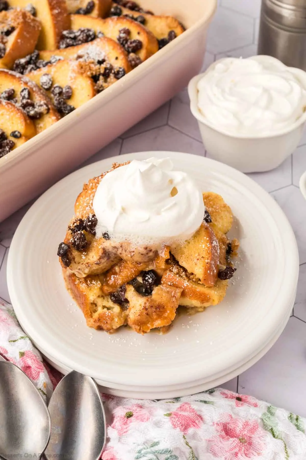 Bread pudding on a plate with whipped cream.