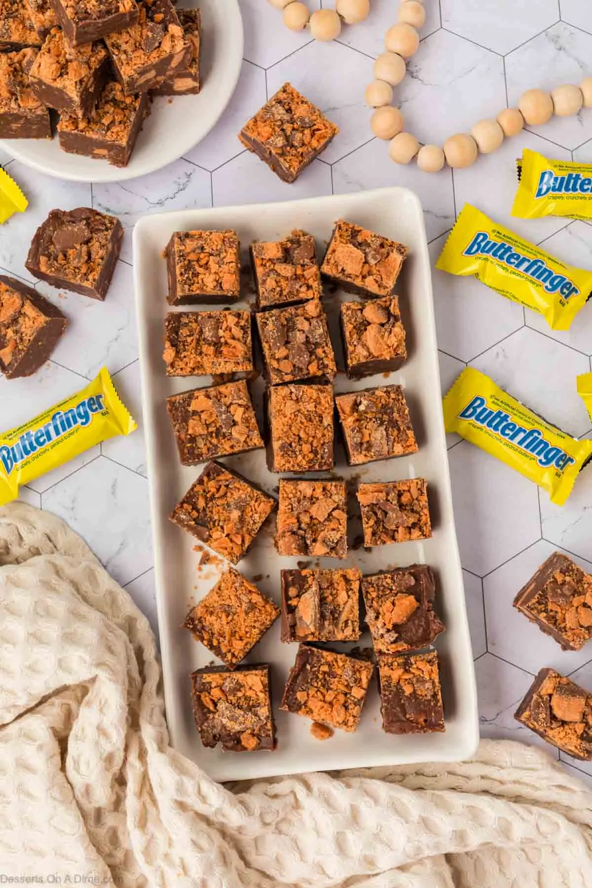 Butterfinger fudge cut into squares on a white platter.
