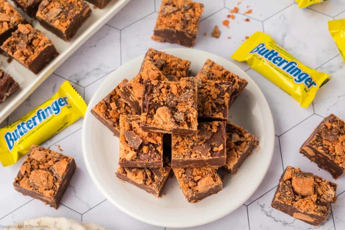 Butterfinger fudge cut into squares on a white plate.