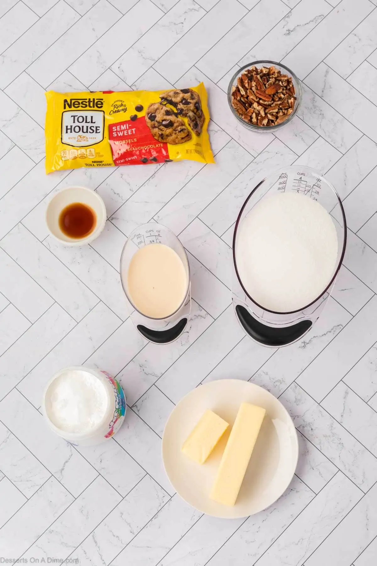 Ingredients for fudge - butter, sugar, milk, chocolate chips, marshmallow fluff, chopped pecans. 