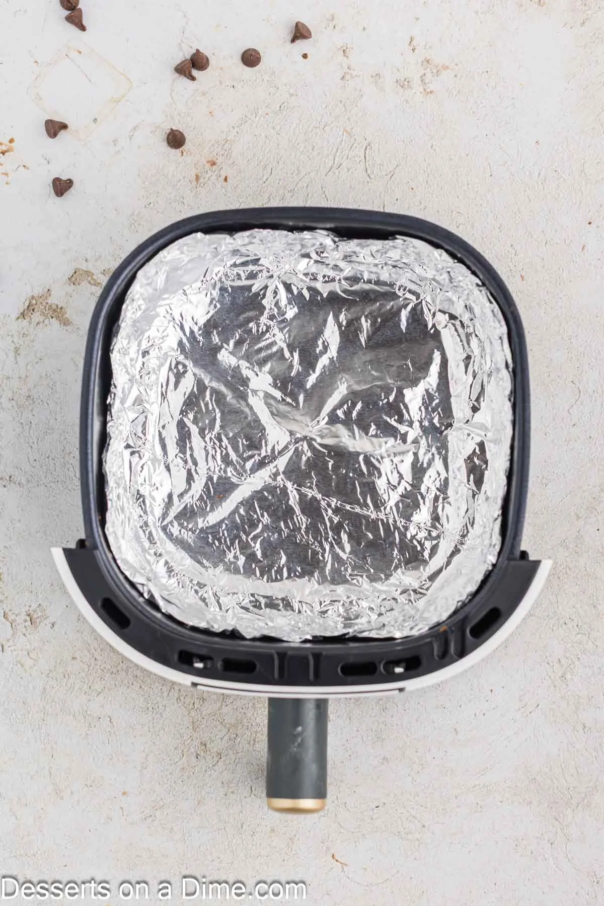 Air fryer basket lined in foil. 