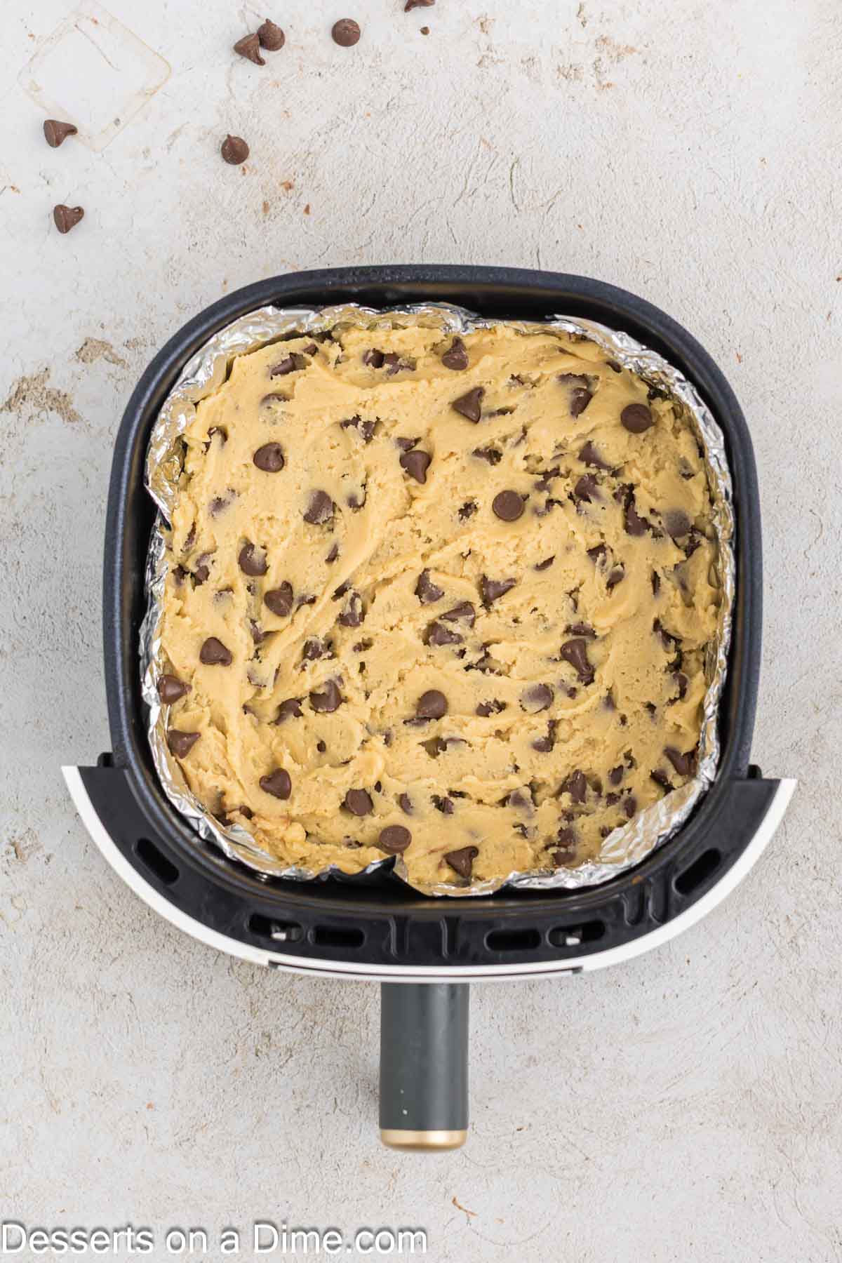Chocolate chip dough pressed into air fryer basket. 