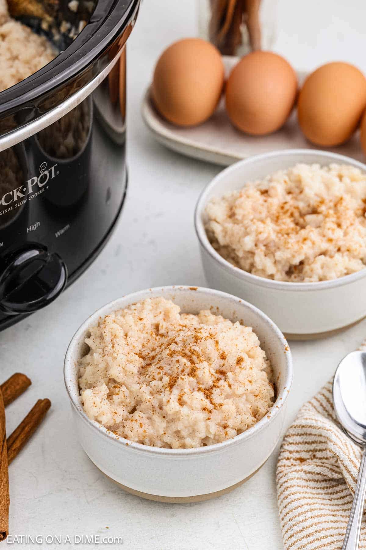 Rice pudding served in white bowls and topped with more cinnamon. 