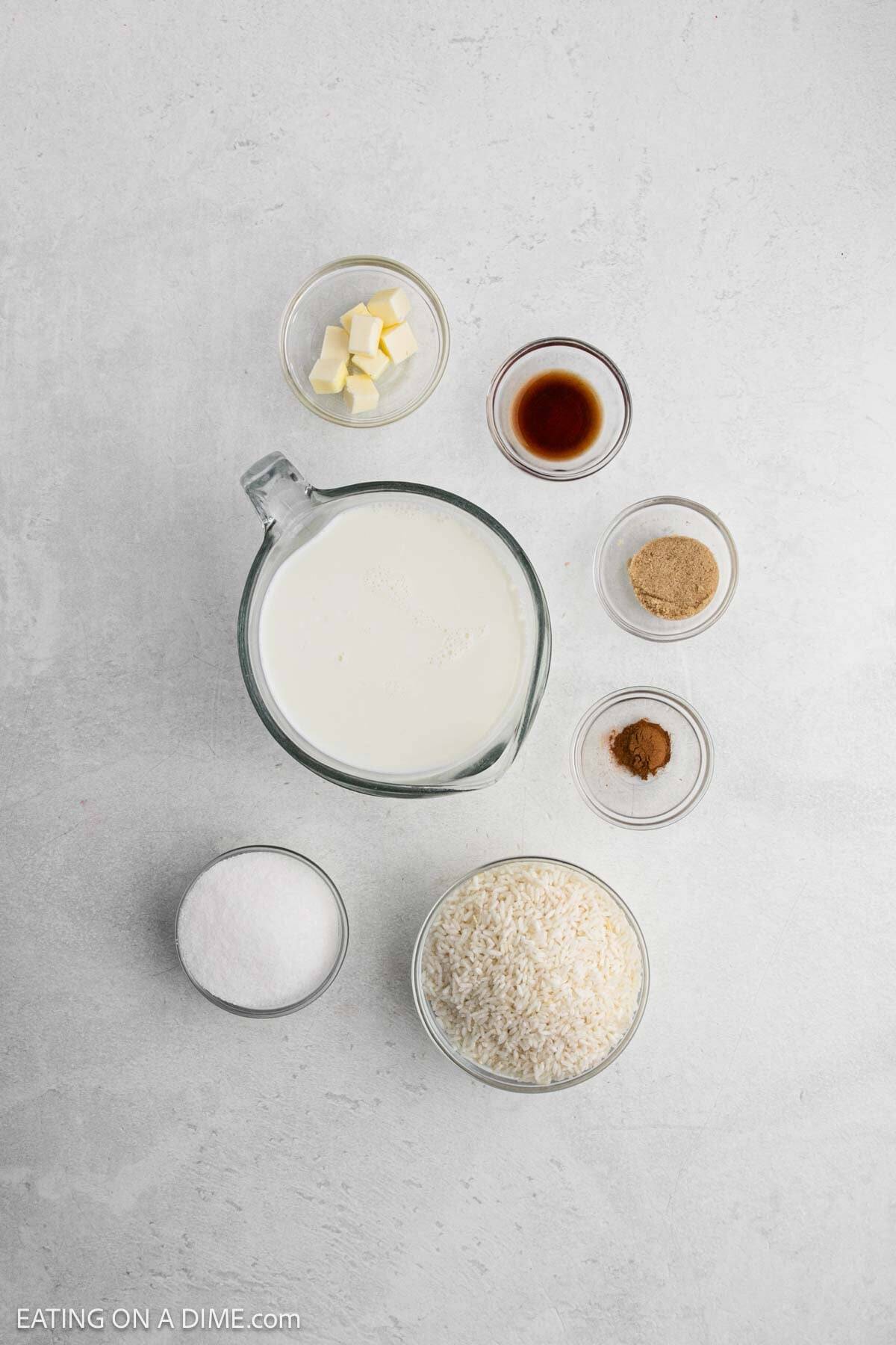 Ingredients for crock pot rice pudding - milk, sugar, brown sugar, instant rice, cinnamon, vanilla, butter. 