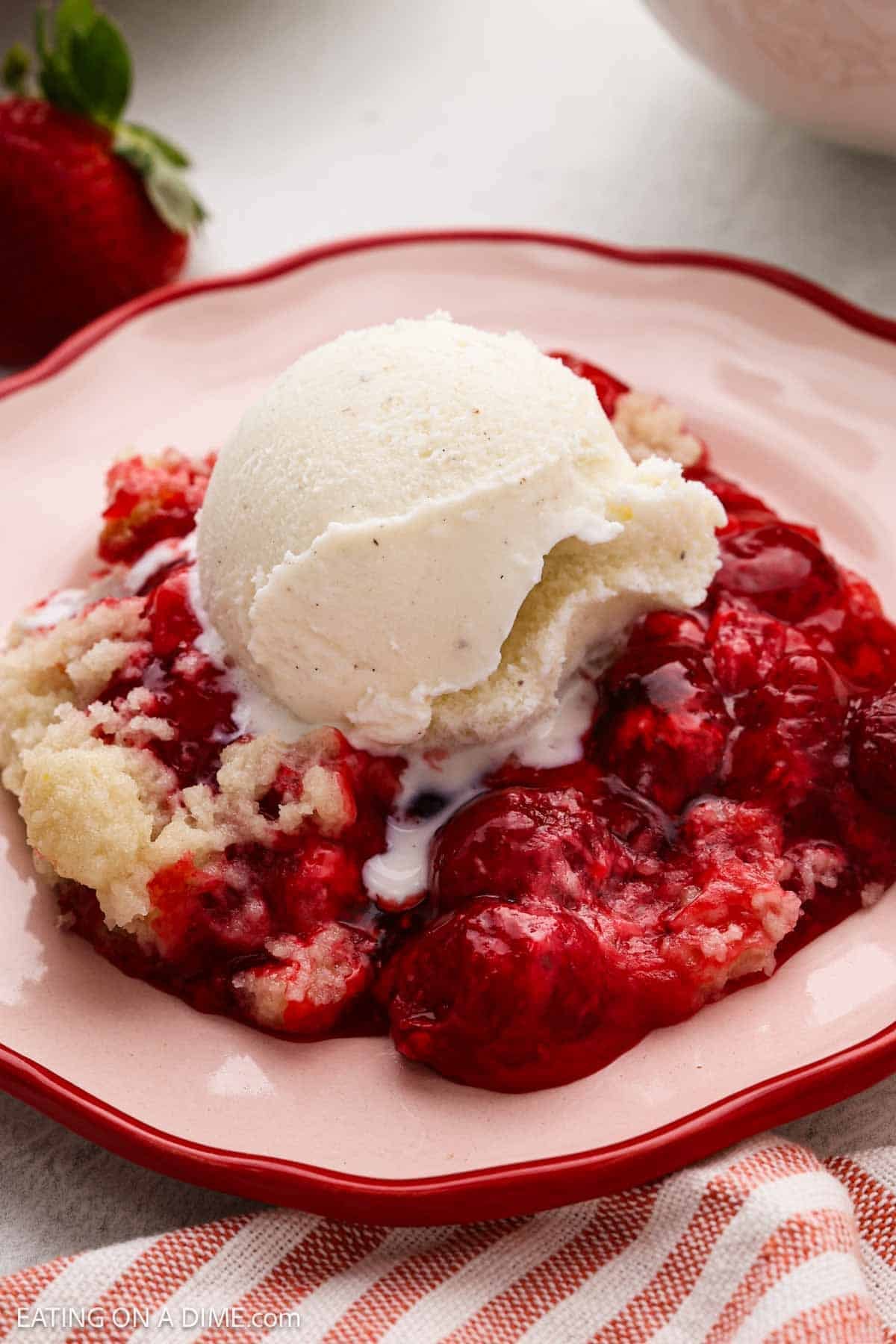Crock Pot Strawberry Dump Cake topped with ice cream. 