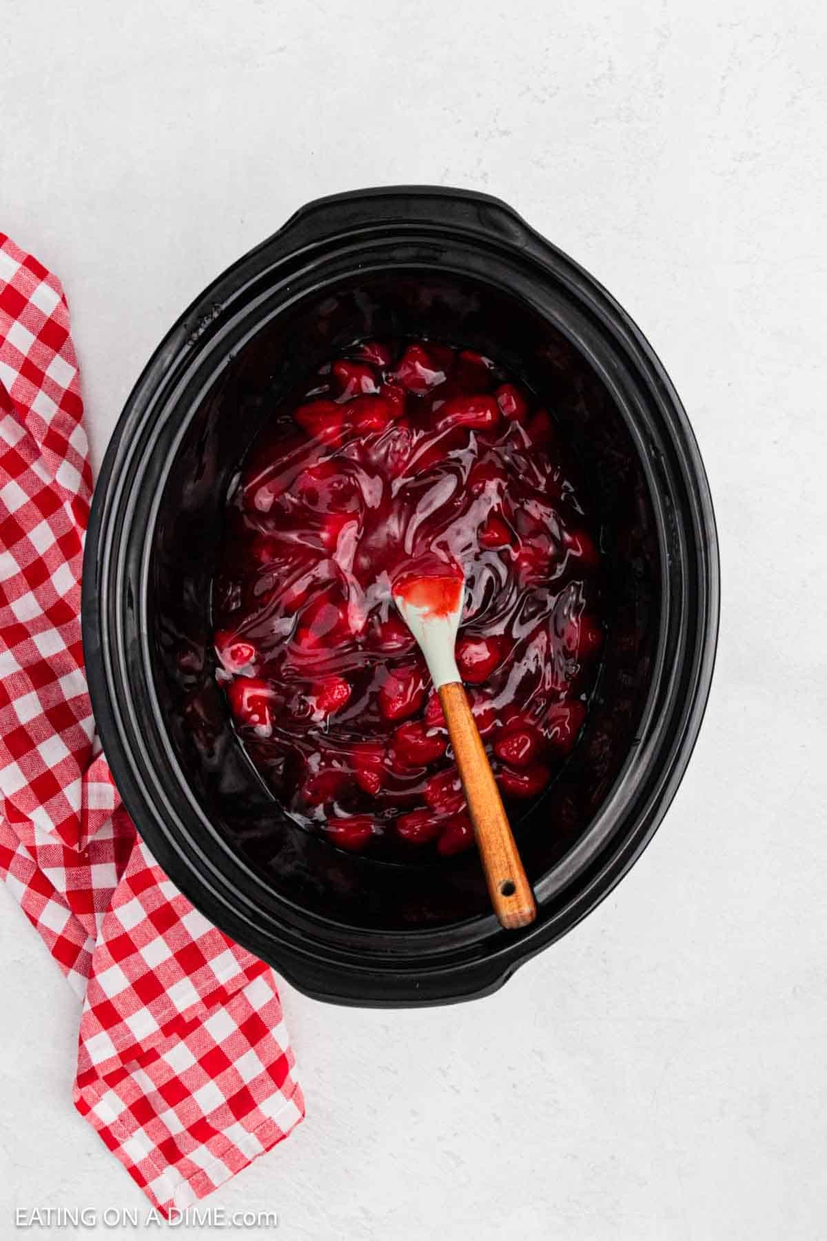 Strawberry pie filling spread on bottom of crock pot. 