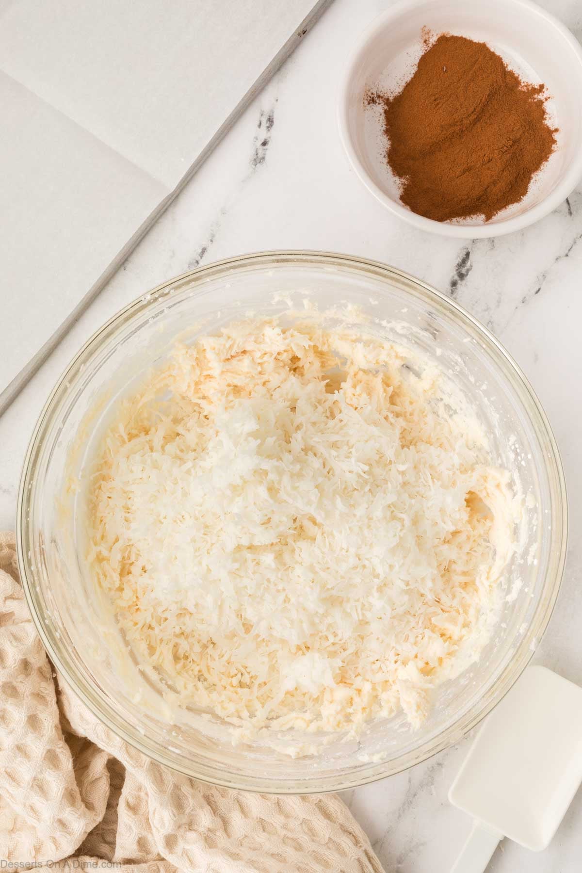 Shredded coconut added into bowl. 