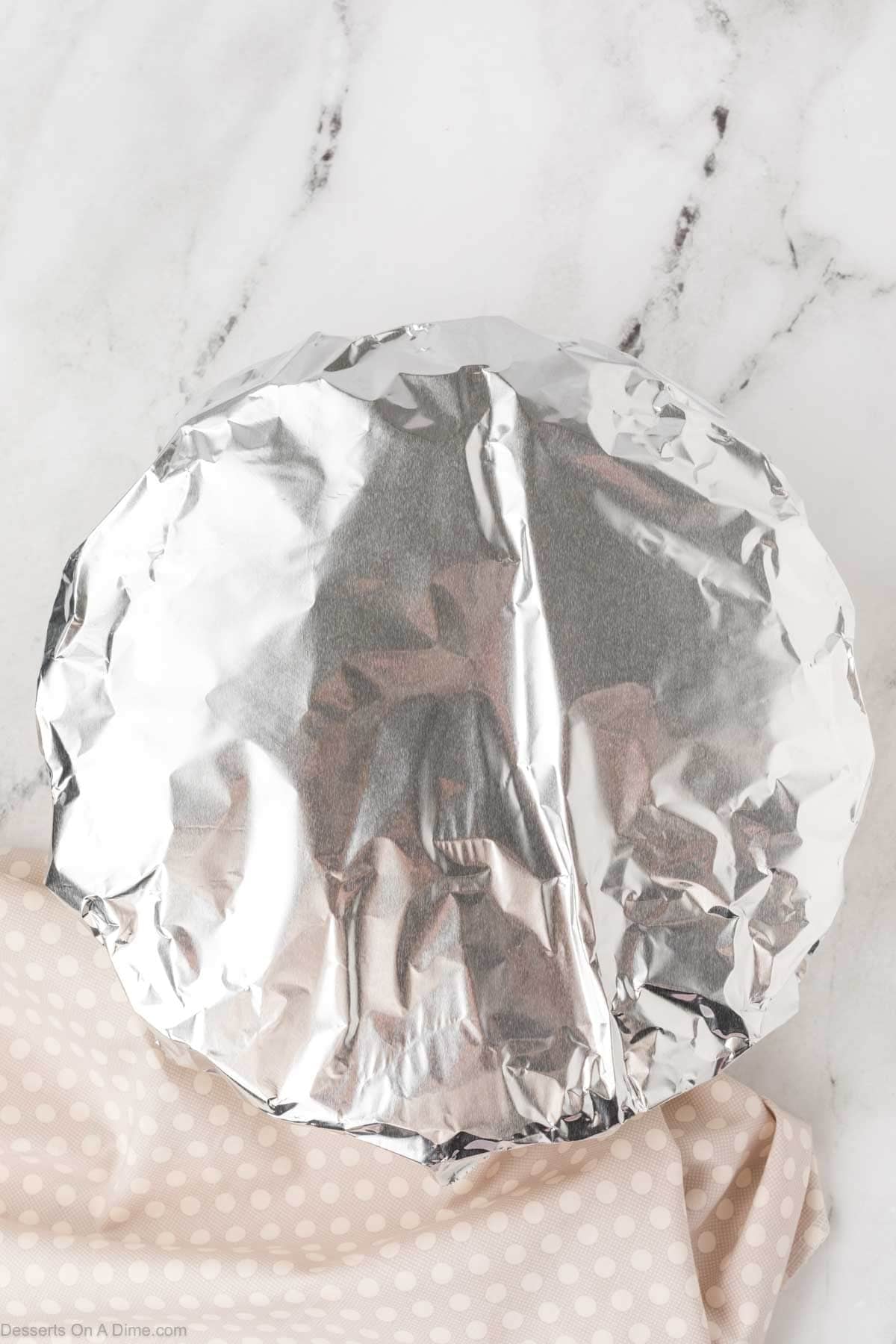 Foil placed on top of cake. 