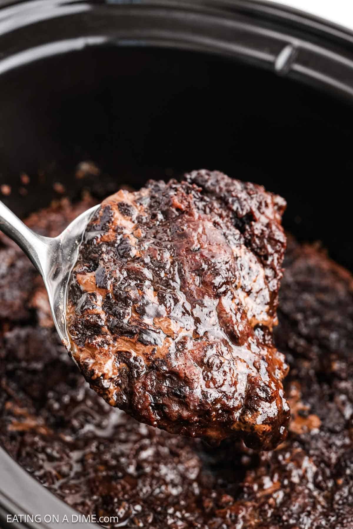 Spoon in slow cooker scooping dessert.