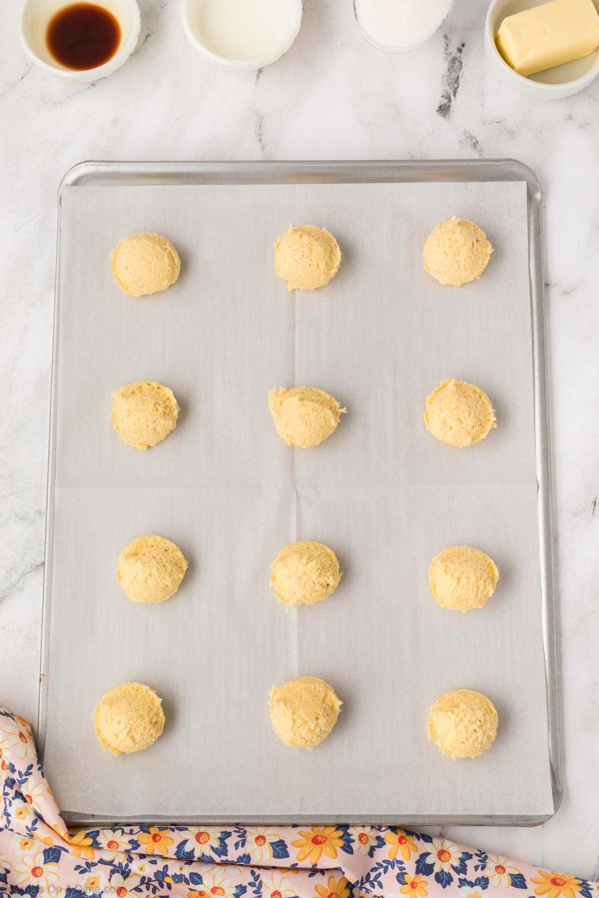 cookie dough balls on a baking sheet lined with parchment paper