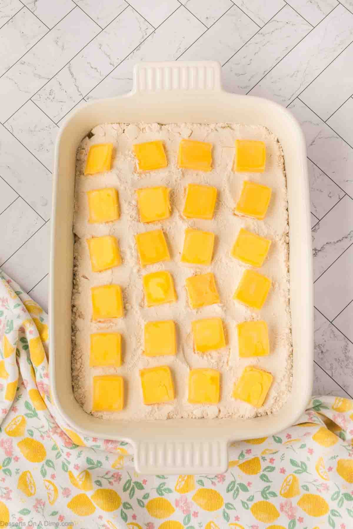 Butter squares on top of cake mix. 