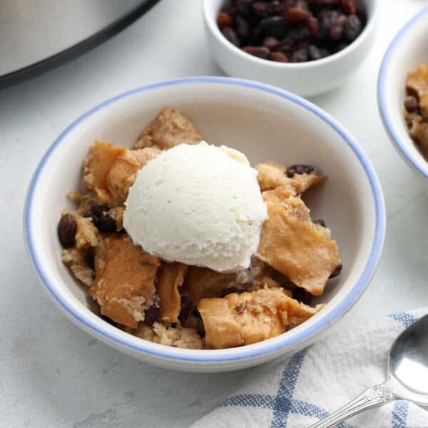 Crockpot bread pudding in bowls with ice cream.
