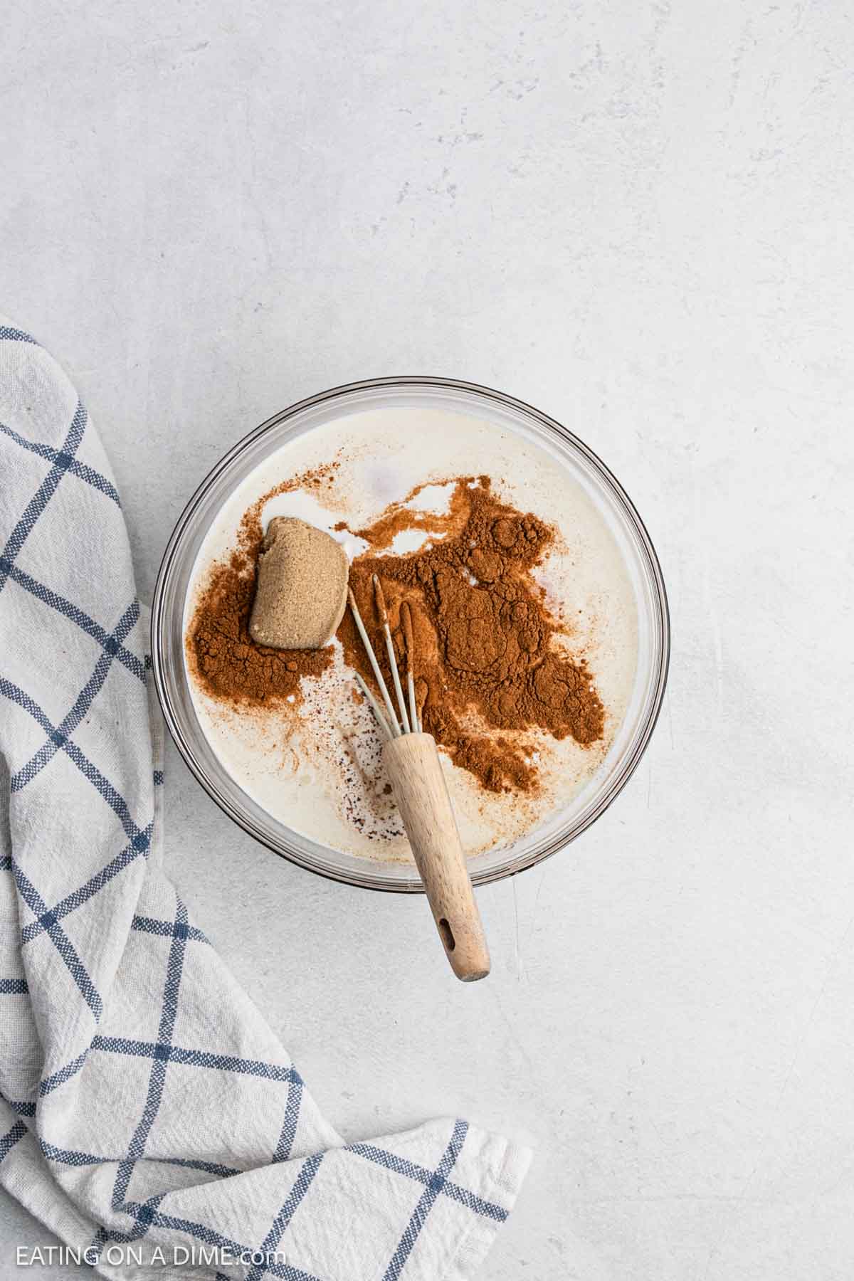 Milk, cream, eggs and cinnamon combined in a bowl. 