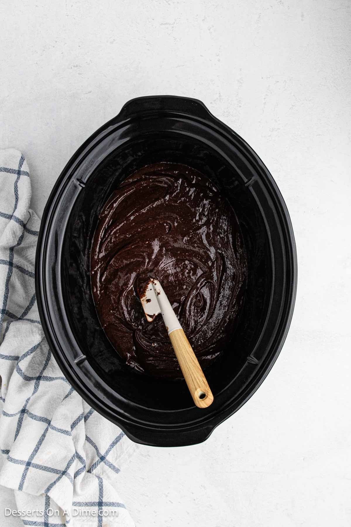 Brownie mix combined and spread in a crock pot. 