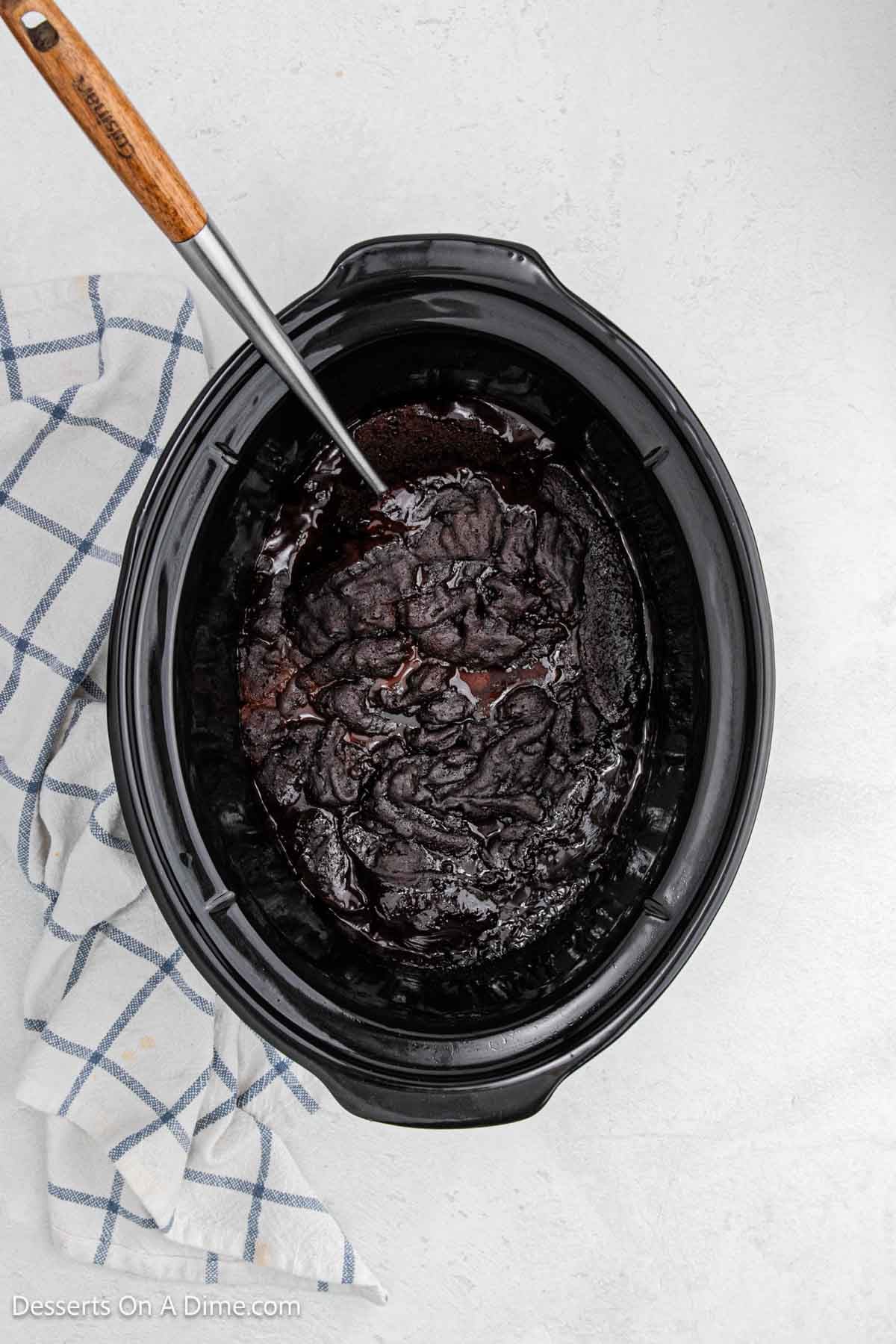 Dessert ready to serve with a spoon in the slow cooker. 