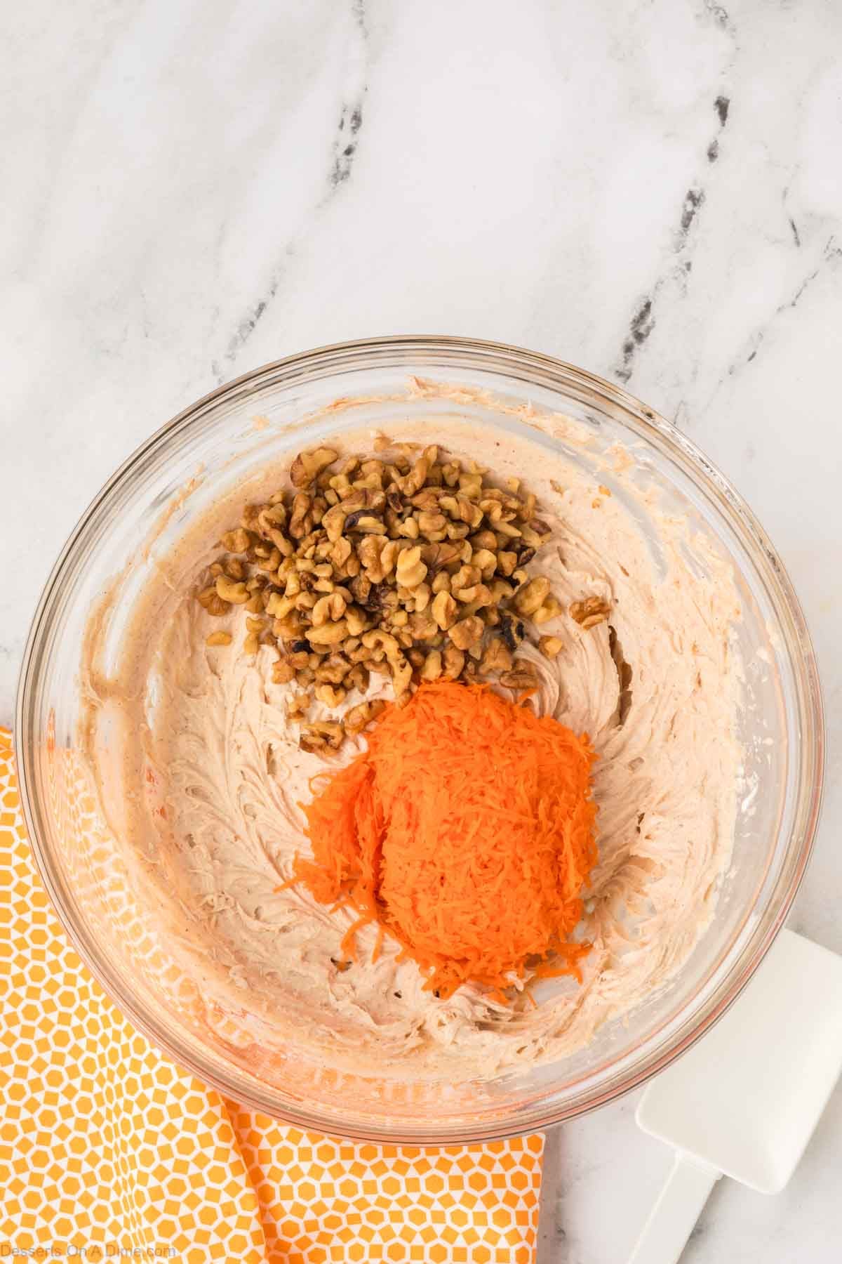 Carrots and nuts added to bowl. 
