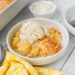 Coconut Dump Cake in a bowl with ice cream.