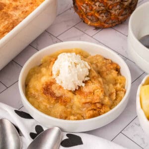 Pineapple Dump Cake in a bowl with ice cream.