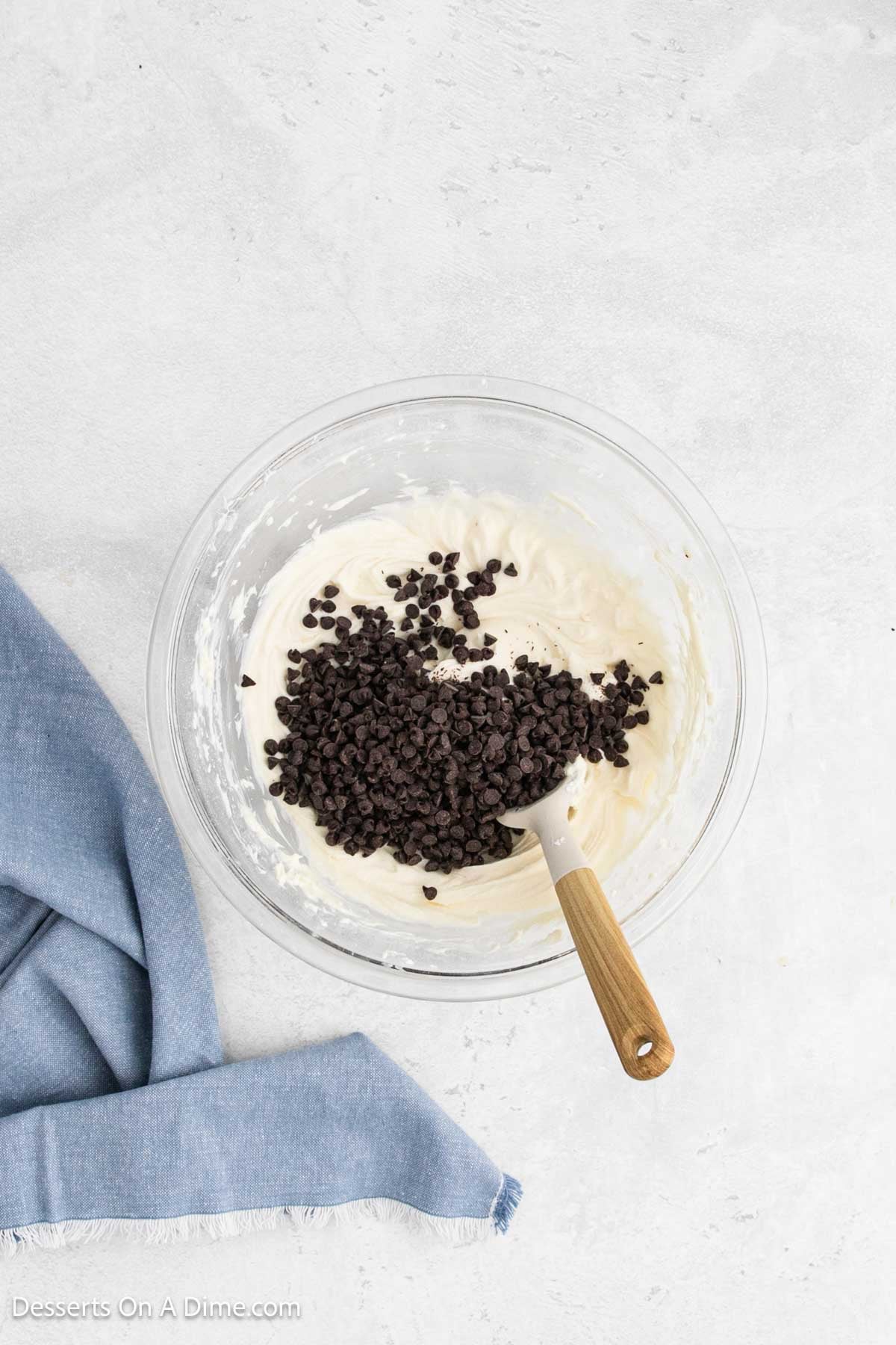 Chocolate chips folded into mixture in bowl. 