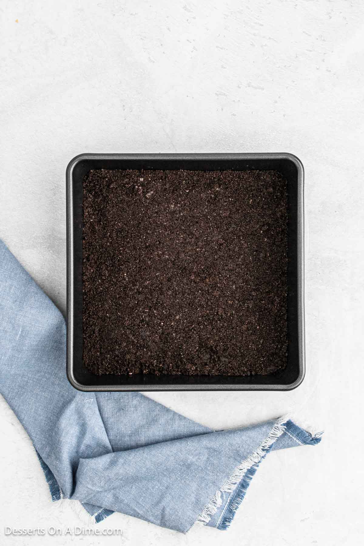 Oreo crumbs pressed into baking dish.