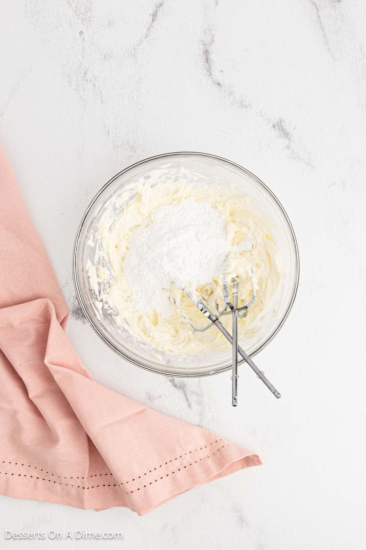 Powdered sugar added to mixture in bowl. 