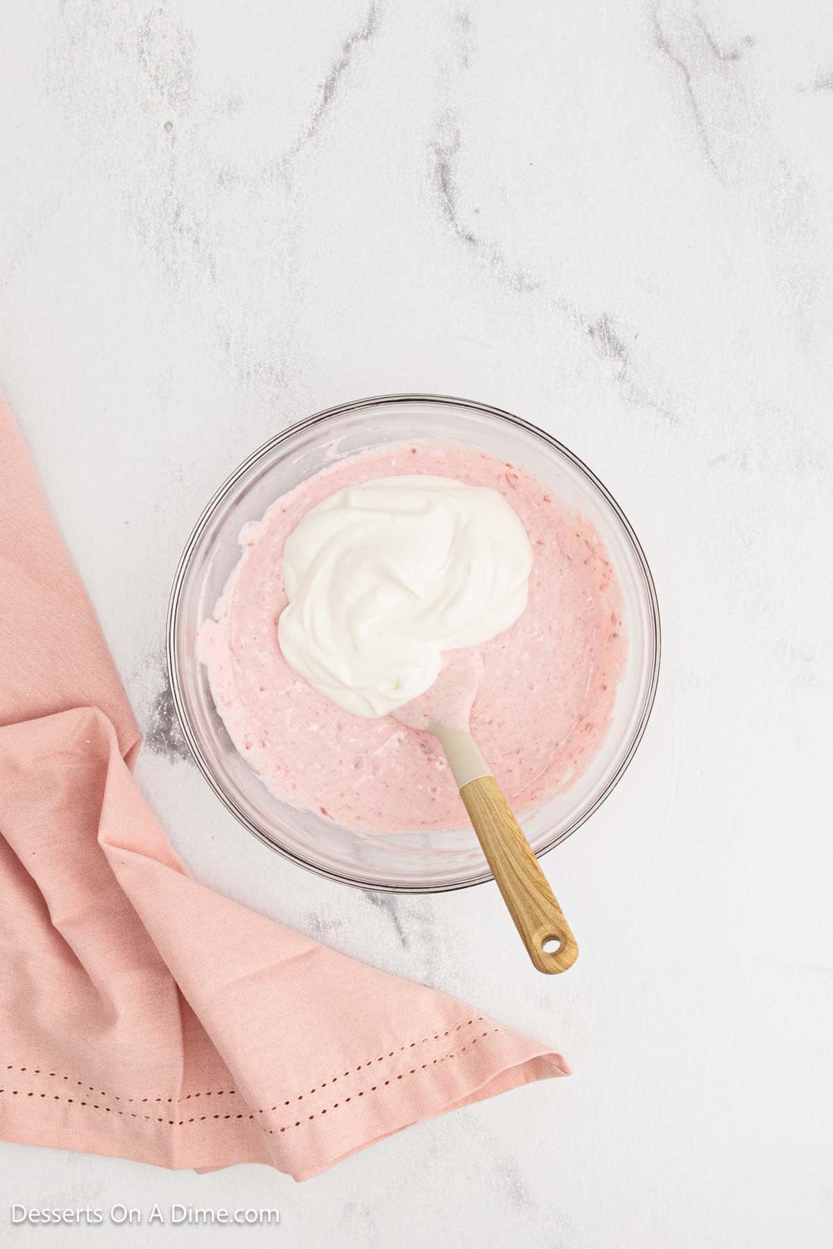 Whipped cream folded into mixture in bowl. 