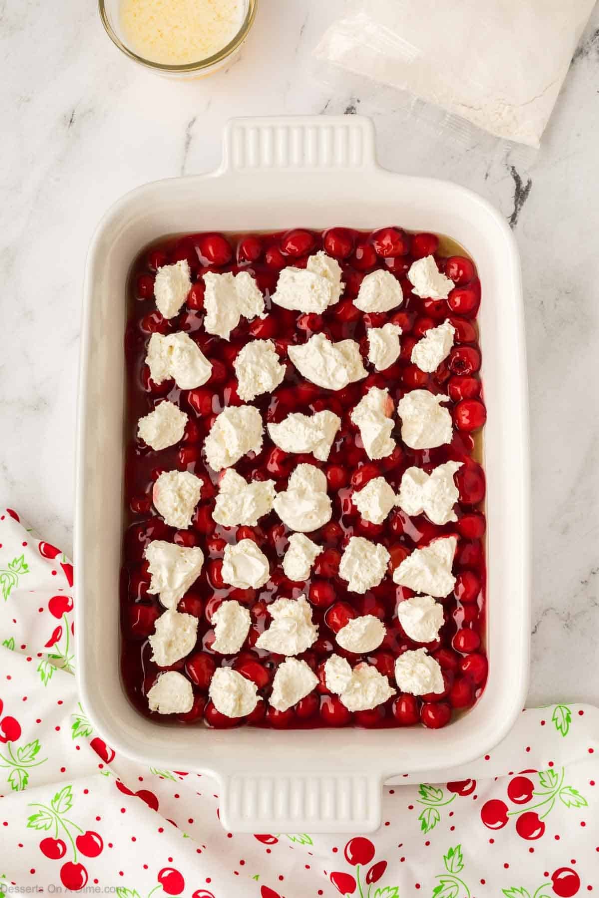 Dollops of cream cheese on top of cherry pie filling. 