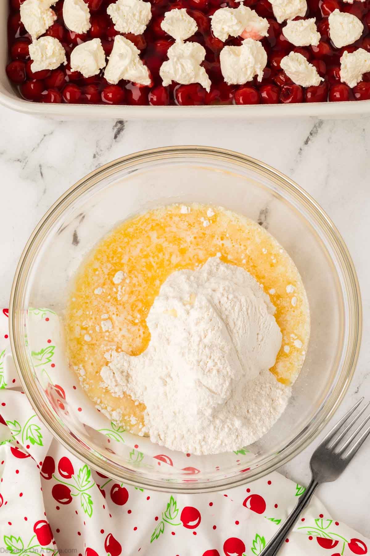 Mixing bowl with cake mix and butter being combined. 