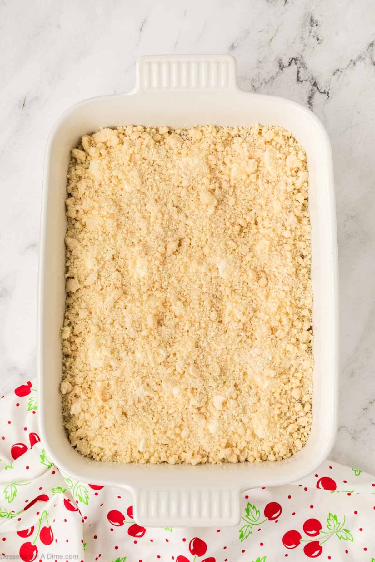 Cake mix spread over top of cream cheese layer. 