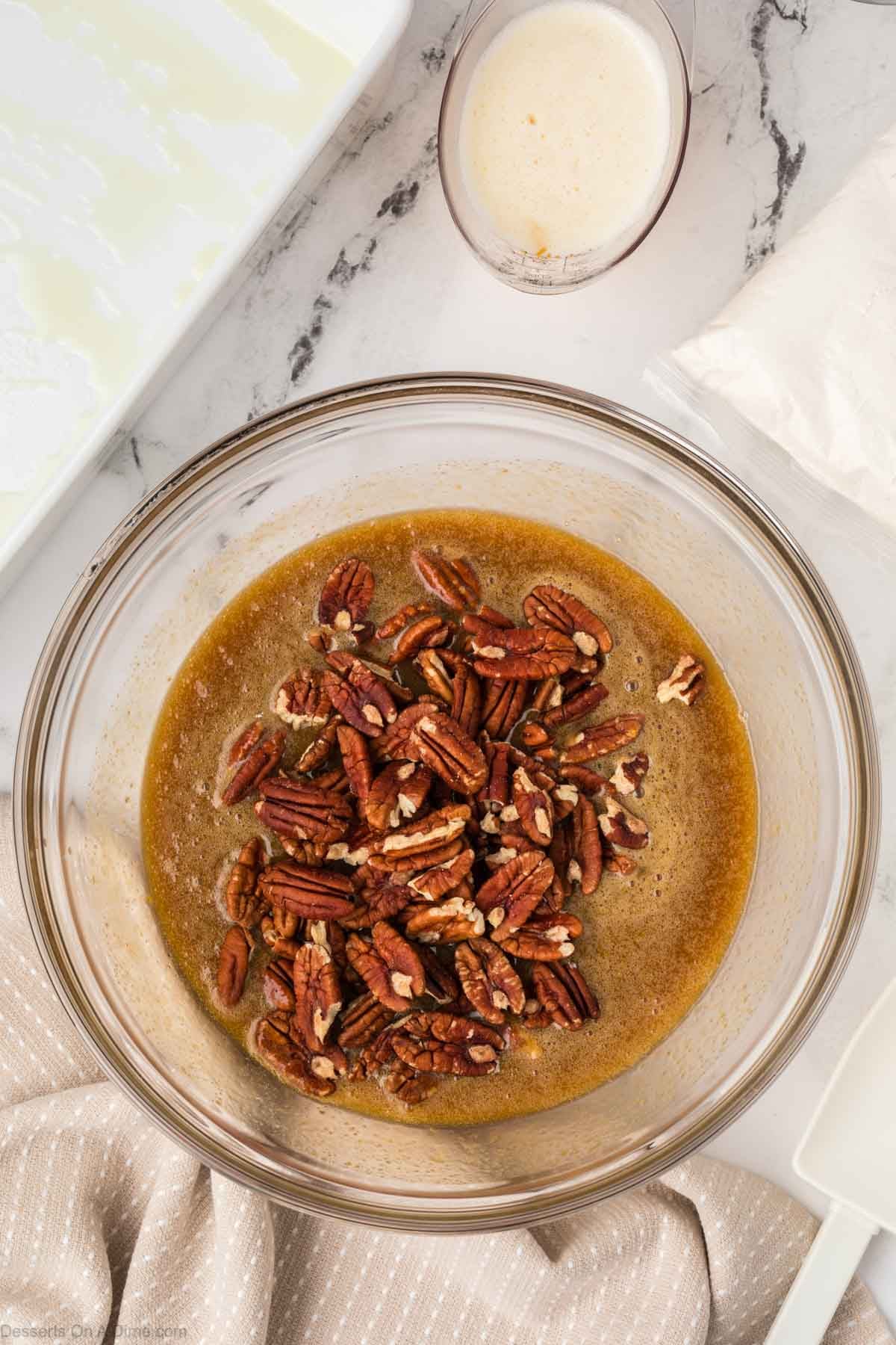 Pecans added to mixture in bowl. 