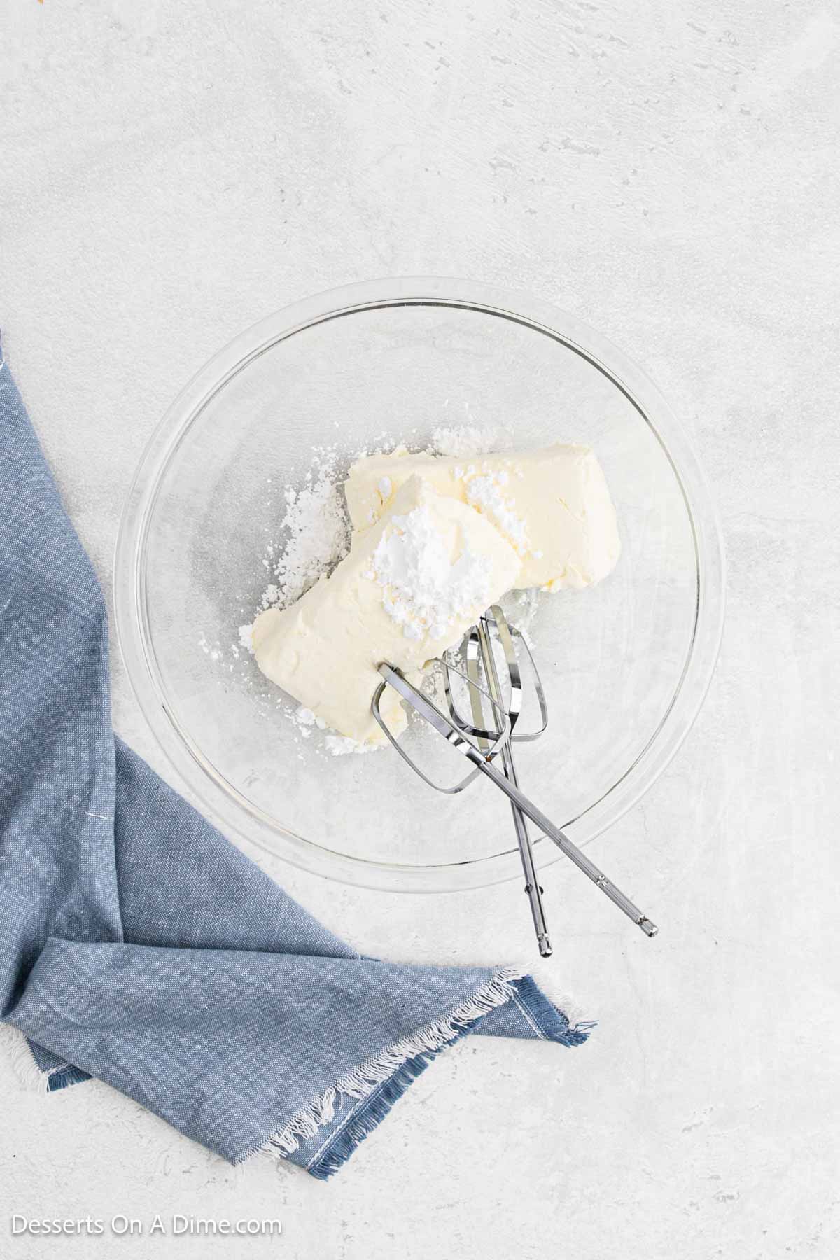Mixing bowl with softened cream cheese and powdered sugar.
