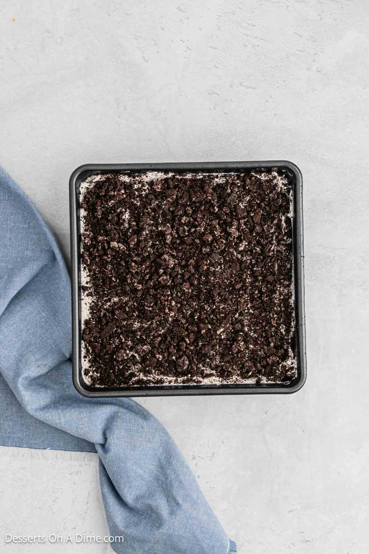 Crumbled cookies sprinkled on top of baking dish.