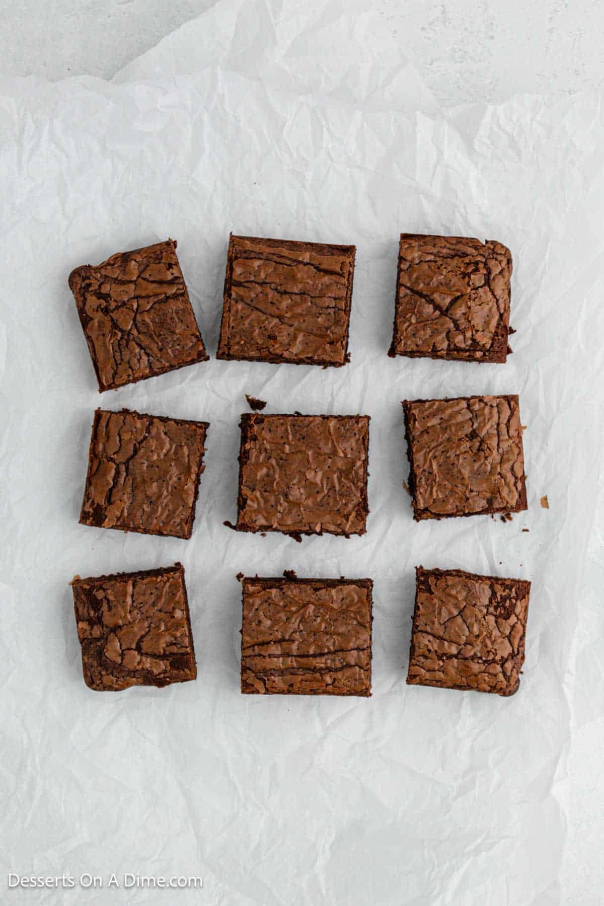 Brownis cut into bars on parchment paper.