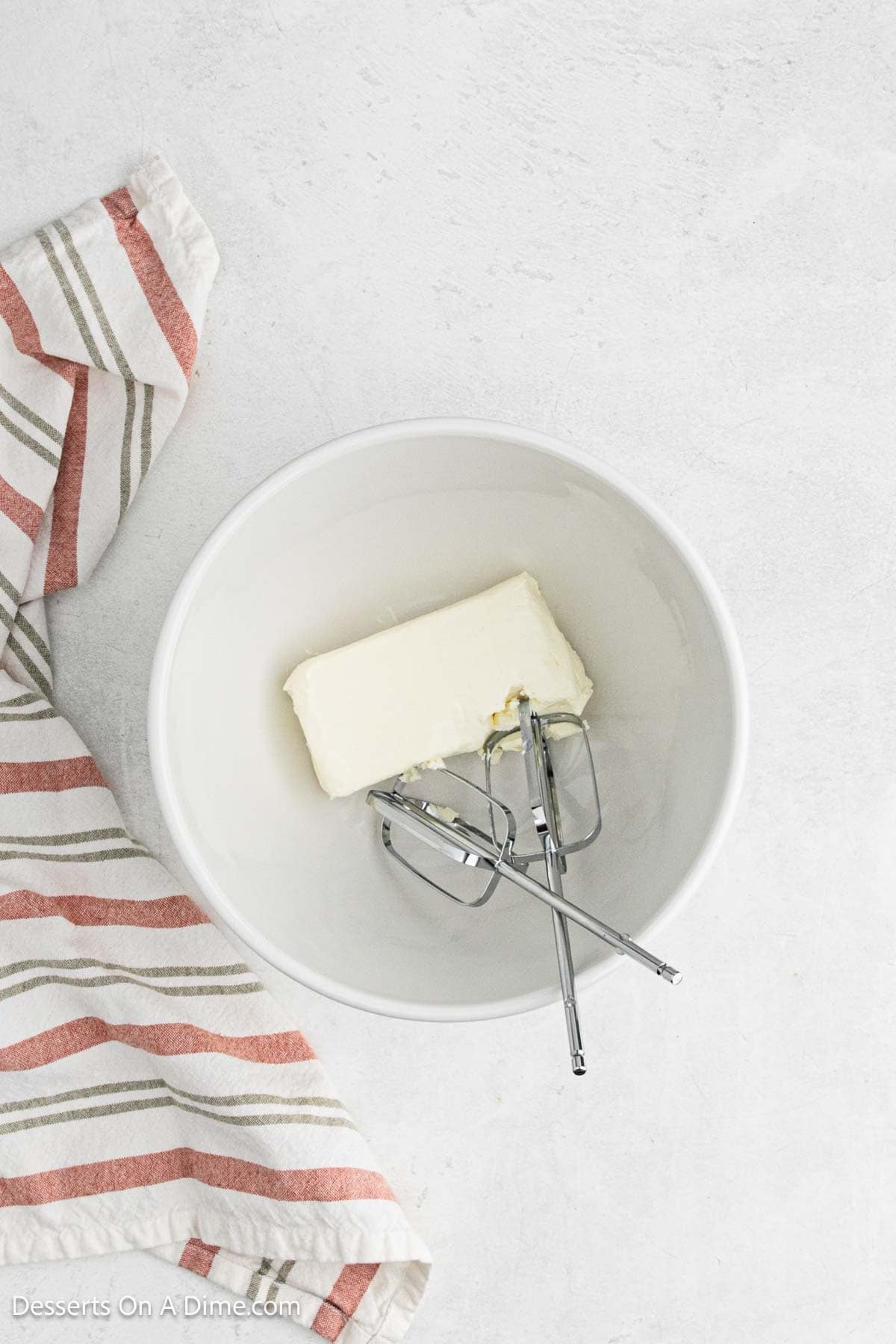 Cream cheese in a bowl with beaters.