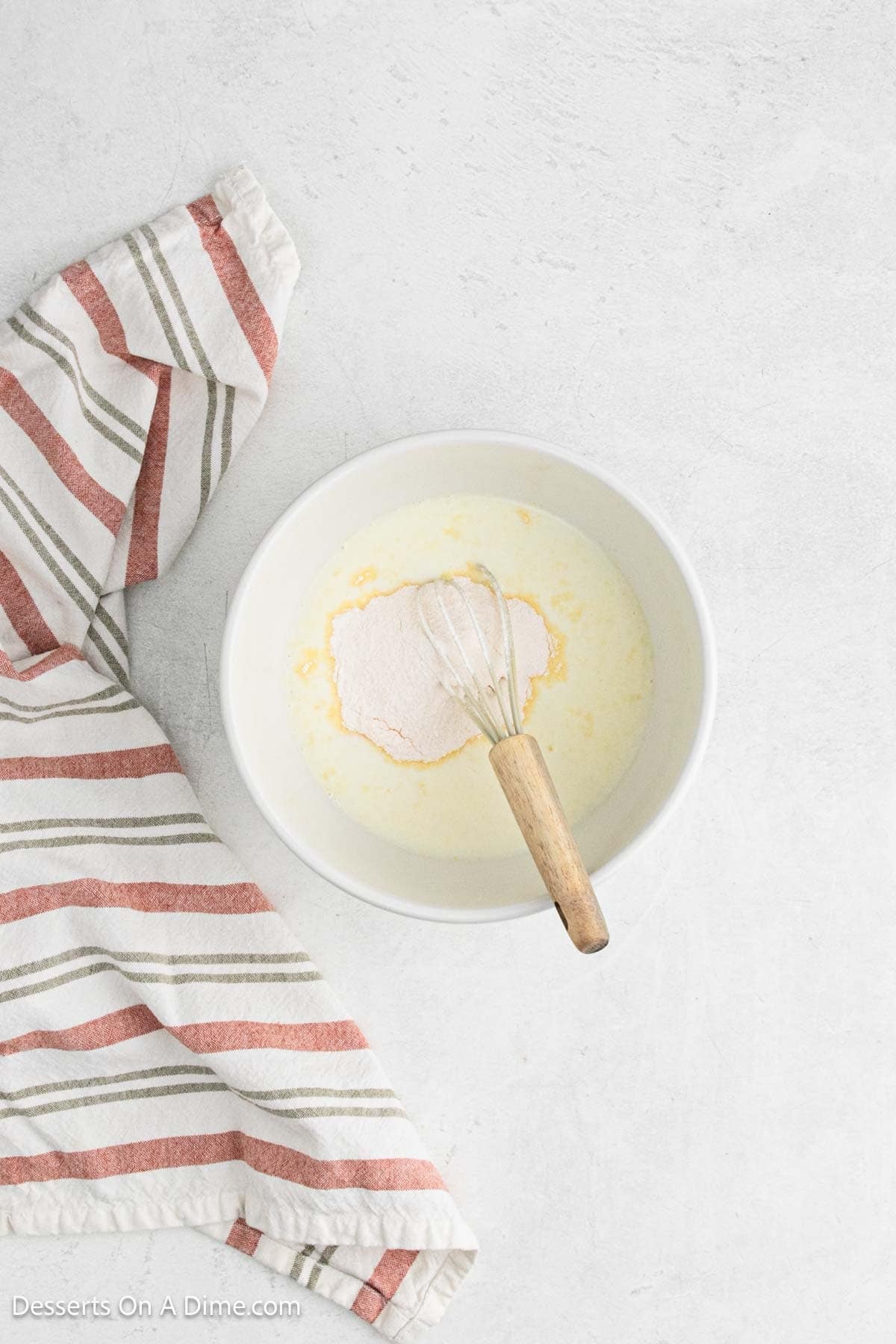Mixing bowl with pudding mix and milk being combined.