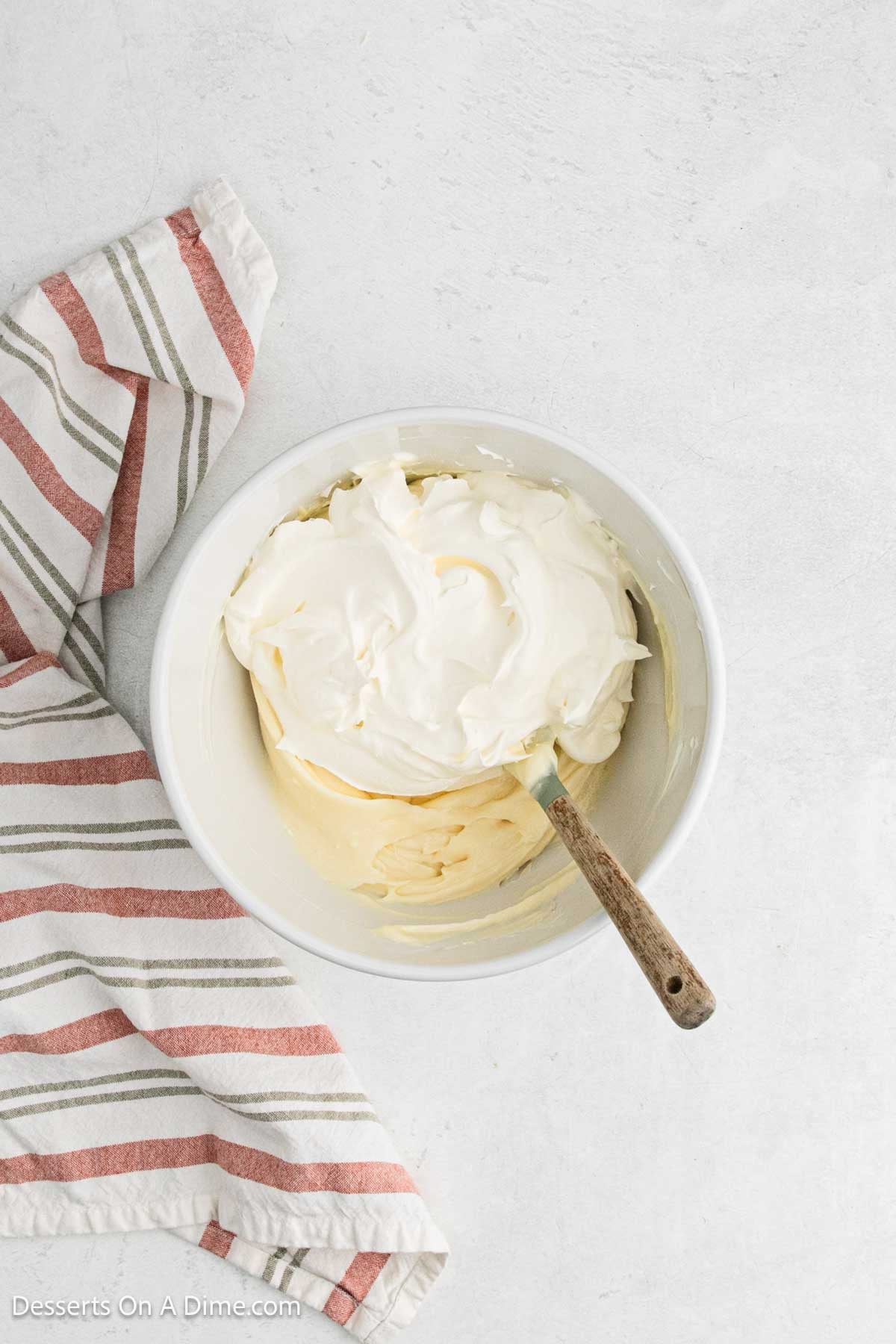 Whipped topping folded into mixture in bowl.