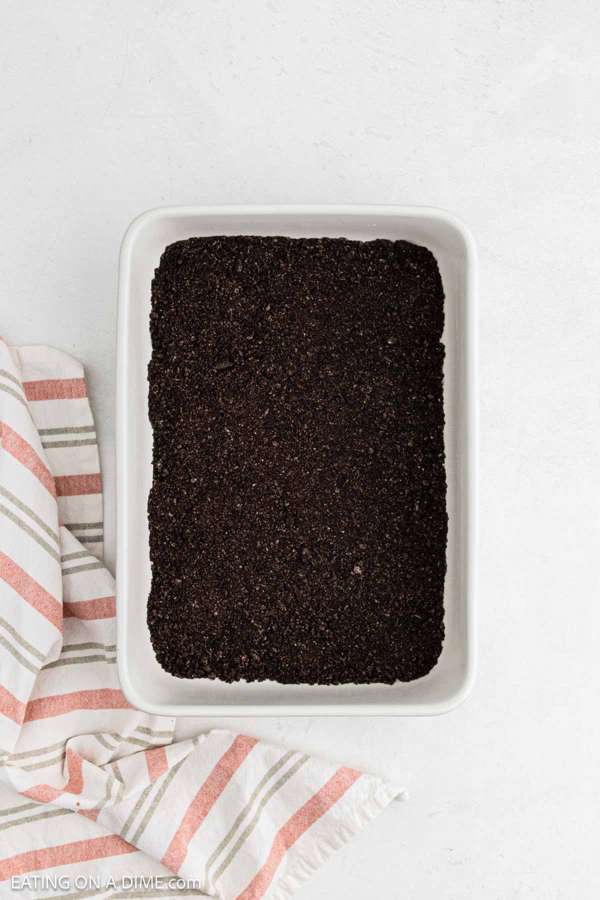 Layered of crushed cookies in baking dish.