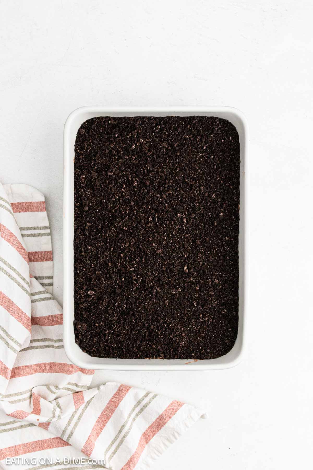 Crushed cookies evenly spread over layer of pudding in baking dish.