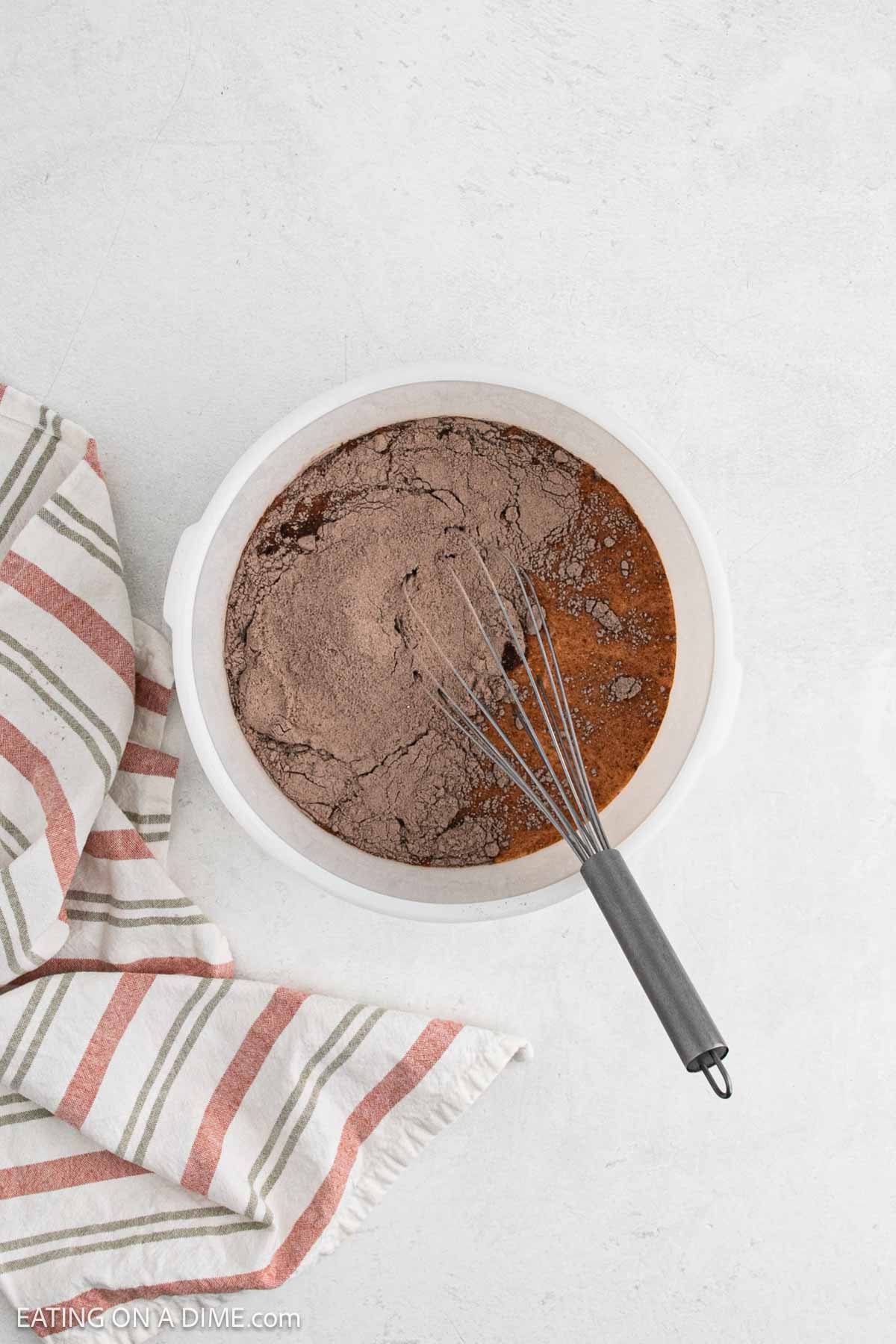 Chocolate pudding and milk whisked together in a mixing bowl. 