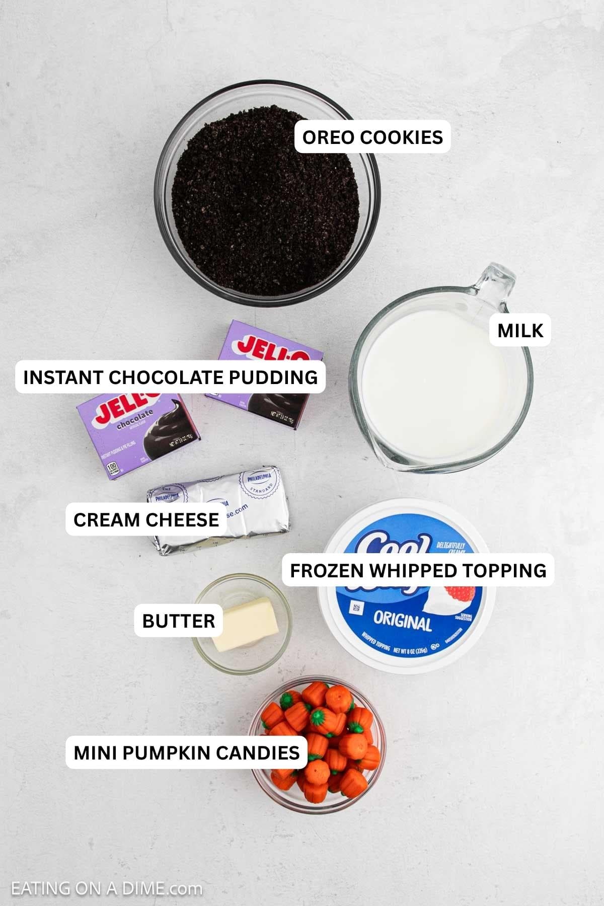 Ingredients for recipe: mini pumpkin candies, butter, whipped topping, cream cheese, milk, instant chocolate pudding and Oreo cookies.